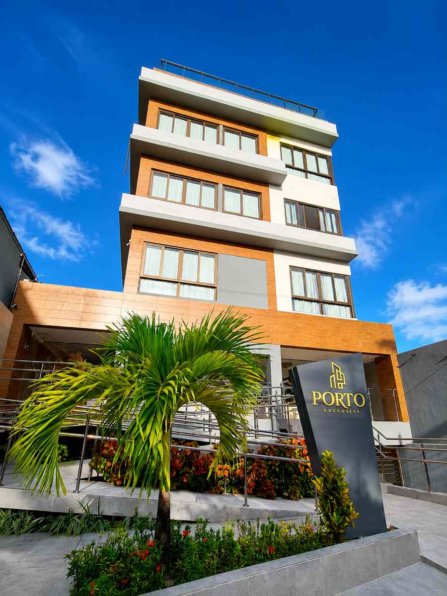 Fachada do Hotel Porto Exclusive com coqueiros